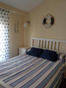 1 dormitorio con cama con almohadas azules y espejo en La Casuca de Suances, en Suances
