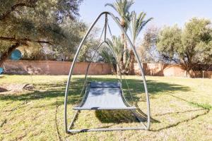 eine Schaukel im Gras im Hof in der Unterkunft Riad salix d'agafay in Marrakesch