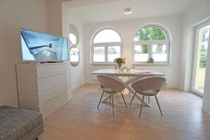 una sala da pranzo con tavolo e TV di Haus Sanke strandnah a Ahlbeck