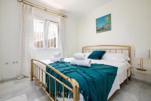 a bedroom with a bed with a green blanket on it at Casa Penney in Denia