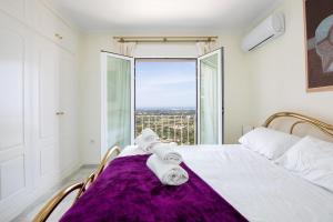 デニアにあるカサ ペニーのベッドルーム1室(紫の毛布と窓付)