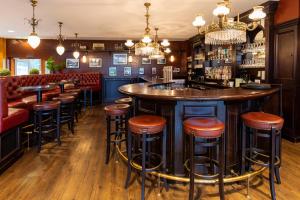 a bar in a restaurant with stools and a counter at Dormio Resort Obertraun in Obertraun