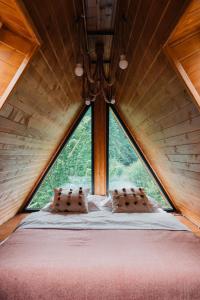 a bedroom in a tree house with a large window at Campulung Chalet A Frame in Câmpulung +38 photos