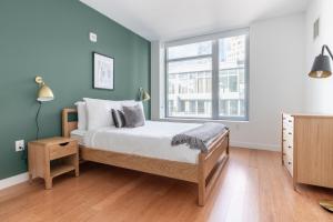 Una cama o camas en una habitación de Downtown 1BR w Gym Doorman nr S Station BOS-246