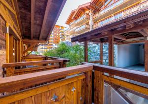 un balcón al aire libre de un edificio de madera con vigas de madera en Nendaz 4 Vallées & SPA 4* Superior en Nendaz