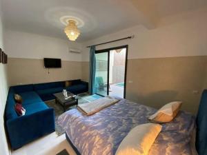 a bedroom with a blue bed and a blue couch at Douiria salix agafay in Marrakech