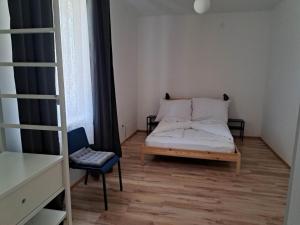 a small bedroom with a bed and a chair at Tarcal Apartman in Tarcal