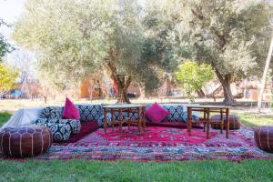 un divano con due tavoli su un tappeto nell'erba di Douiria salix agafay a Marrakech