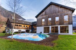 a large house with a large painting in front of it at Dormio Resort Obertraun in Obertraun