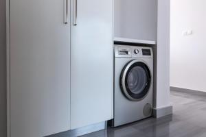 a washing machine in a kitchen next to a cabinet at Premier 401 3 bedroom penthouse in Paphos City