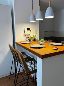 una cocina con una mesa con sillas y luces en Center Suites Alquiler Temporario en La Plata
