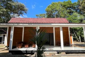 a small house with a red roof at Capital O 92612 Penginapan D'alas Purwo & Beach in Banyuwangi