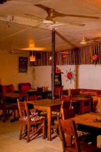 une salle à manger avec des tables et des chaises en bois dans l'établissement Taste of Mexico Hostel, à Dar es Salaam
