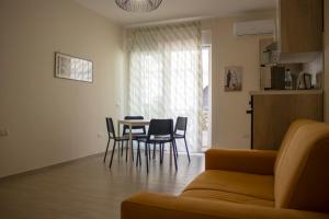 sala de estar con sofá, mesa y sillas en Appartamento via Roma, en Recale