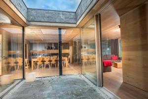a glass house with a living room and dining room at Smaragdresort in Bramberg am Wildkogel