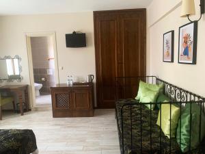 Mitos Hotel في بوزجادا: غرفة معيشة بها أريكة وتلفزيون