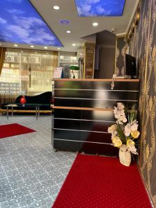 a lobby with a red carpet and a desk with flowers at Metropol hotel 2 in Istanbul