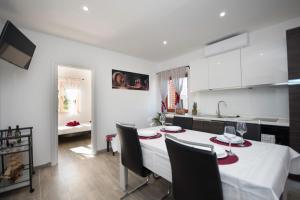 a kitchen with a table and chairs and a kitchen with white cabinets at Relax House Kanica in Zaglavice