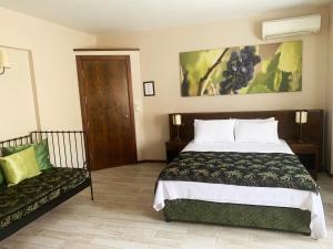 a bedroom with a large bed and a couch at Mitos Hotel in Bozcaada