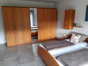 - une chambre avec 2 lits et des placards en bois dans l'établissement Villa Laffenau, à Heideck