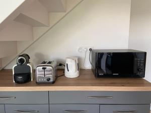 a microwave sitting on top of a kitchen counter at Le clos Saint Denis in Saint-Denis-en-Val