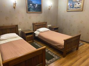 um quarto com duas camas e duas mesas de cabeceira sidx sidx sidx em Hotel Fortetsya Hetmana em Hatne
