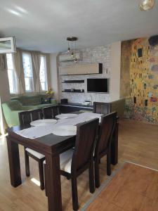 a dining room table with chairs and a living room at Apartment Ventuno 21 in Sliven