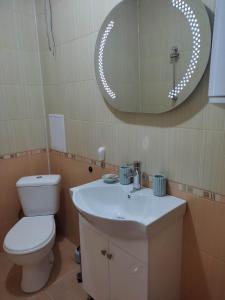 a bathroom with a toilet and a sink and a mirror at Apartment Ventuno 21 in Sliven +24 photos
