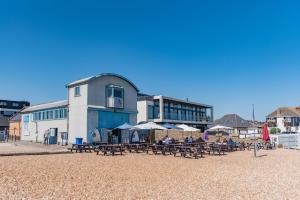 a group of tables and umbrellas on a beach at Prospect Cottage by Bloom Stays in Hythe