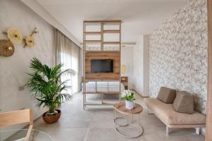 a living room with a couch and a tv at Hotel Globus Pool & Beach in Milano Marittima