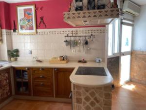cocina con fregadero y pared roja en Circus-Goretti House, en Mairena del Aljarafe