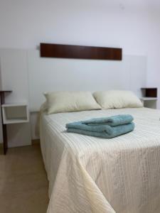 una cama con dos toallas azules sentadas en ella en Departamento SGO en Santiago del Estero