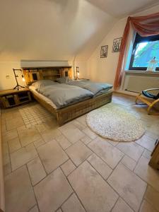 - une chambre avec un lit et une grande fenêtre dans l'établissement Haus am Oberen Eschenbacher Teich, à Clausthal-Zellerfeld