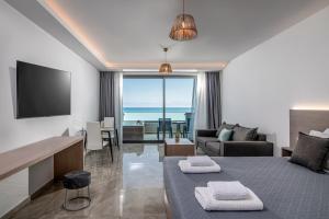 Crete Resort Sea Side Suites "Adults Only" by Checkin في غوفي: فندق غرفه بسرير وصاله