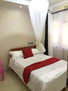 a bedroom with a large bed with a red blanket at Ludali homes in Kakamega