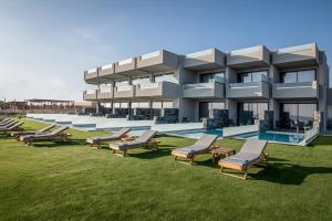 een gebouw met een rij stoelen en een zwembad bij Crete Resort Sea Side Suites "Adults Only" by Checkin in Gouves
