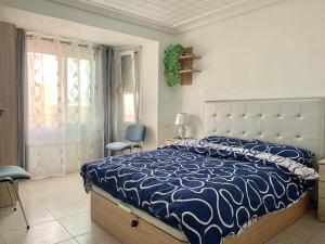 a bedroom with a bed with a blue and white comforter at Casa Angela de Novelda in Novelda