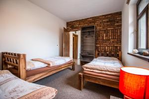 1 Schlafzimmer mit 2 Betten und Ziegelwand in der Unterkunft Apartmány U Babičky in Mutěnice