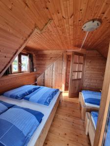 Apartamentowe domki drewniane COLORADO في كارفيا: غرفة نوم في كابينة خشب بها سريرين