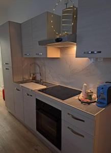 a kitchen with white cabinets and a sink and a stove at Centro storico, Centralissimo LUXURY SMERALDO SUITE Doccia Idromassaggio , cesto con piccola colazione in Ravenna +41 photos