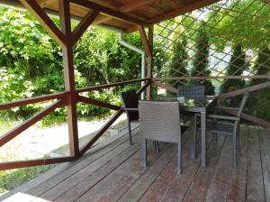 una terraza de madera con mesa y sillas. en Chata Adam en Patince