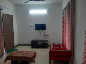 a living room with a chair and a tv at BareFootBay - Villa with Private Beach Access in Chennai