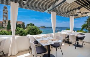 a dining room with a view of the ocean at Beach Bay Hvar Hotel in Hvar