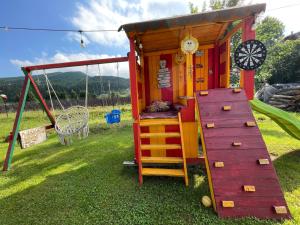 a small playground with a slide and a play house at Casa cu Pitici in Vama