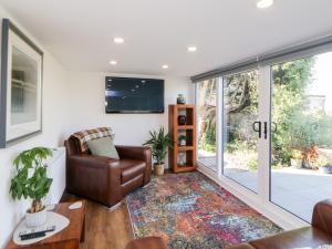 a living room with a leather chair and a tv at Riverview 1 Brunel View in Saltash