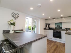 een keuken met witte kasten en een aanrecht bij Riverview 1 Brunel View in Saltash