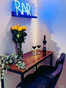 a wooden table with two glasses of wine and flowers at Winchester Retreat in Winchester