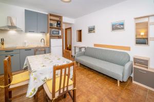 a kitchen and a living room with a table and a couch at Apartmani Ana Juranić in Jurandvor