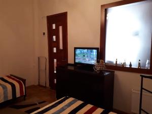 a living room with a television and a window at Уютная квартирка в центре Тбилиси! in Tbilisi City