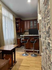 a kitchen with a table and two bar stools at Уютная квартирка в центре Тбилиси! in Tbilisi City